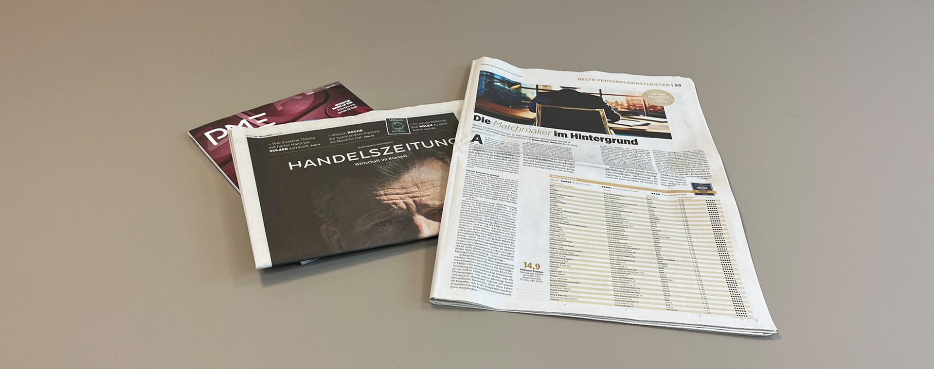 Eine Ausgabe der Handelszeitungen liegt aufgeschlagen neben einer Ausgabe des Magazins PME auf einem Tisch.
