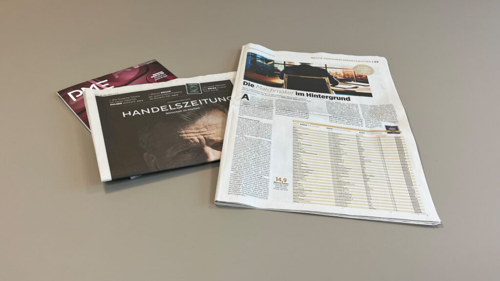 Eine Ausgabe der Handelszeitungen liegt aufgeschlagen neben einer Ausgabe des Magazins PME auf einem Tisch.
