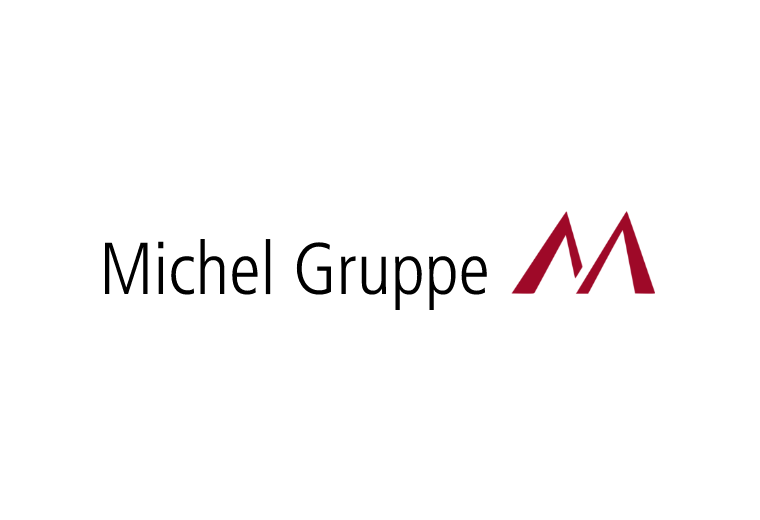 Logo der Michel Gruppe mit schwarzem Schriftzug und stilisiertem roten „M“ aus zwei Dreiecken rechts daneben. Klare, moderne Gestaltung für eine Unternehmensmarke.
